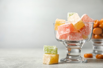Photo of Dessert bowls filled with tasty sweets on light table. Space for text