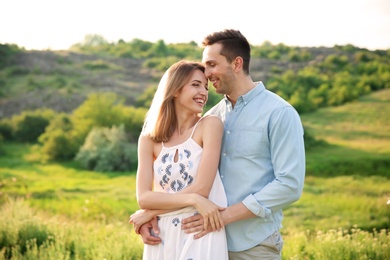 Cute young couple in love posing outdoors on sunny day