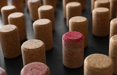 Photo of Many wine bottle corks on black table, closeup