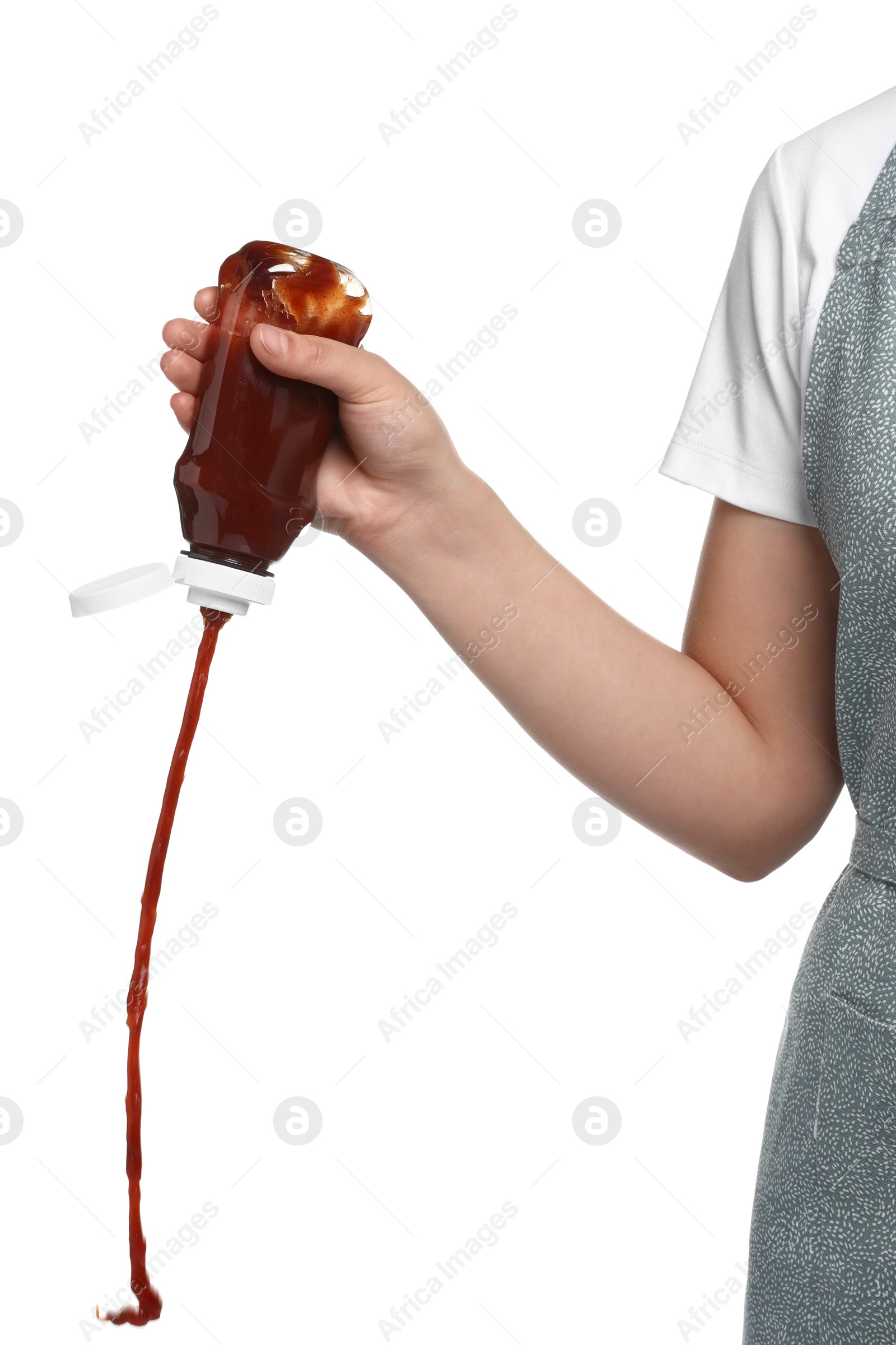 Photo of Woman pouring tasty ketchup from bottle on white background, closeup