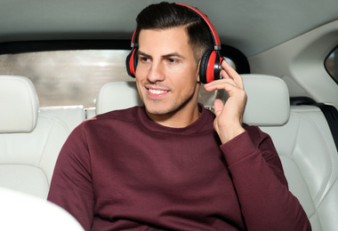 Handsome man listening to audiobook in car