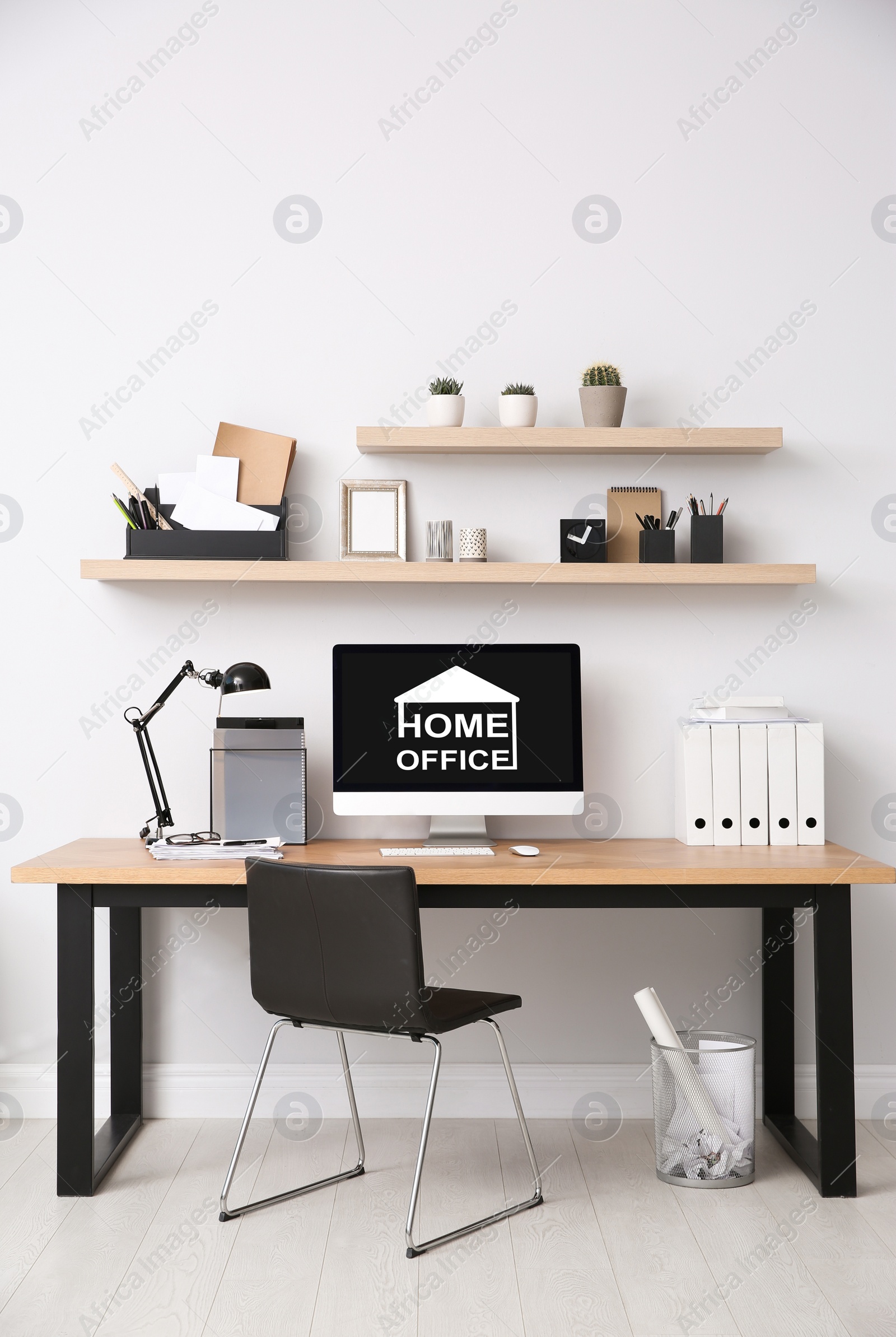 Image of Modern computer with text HOME OFFICE on white wooden indoors 