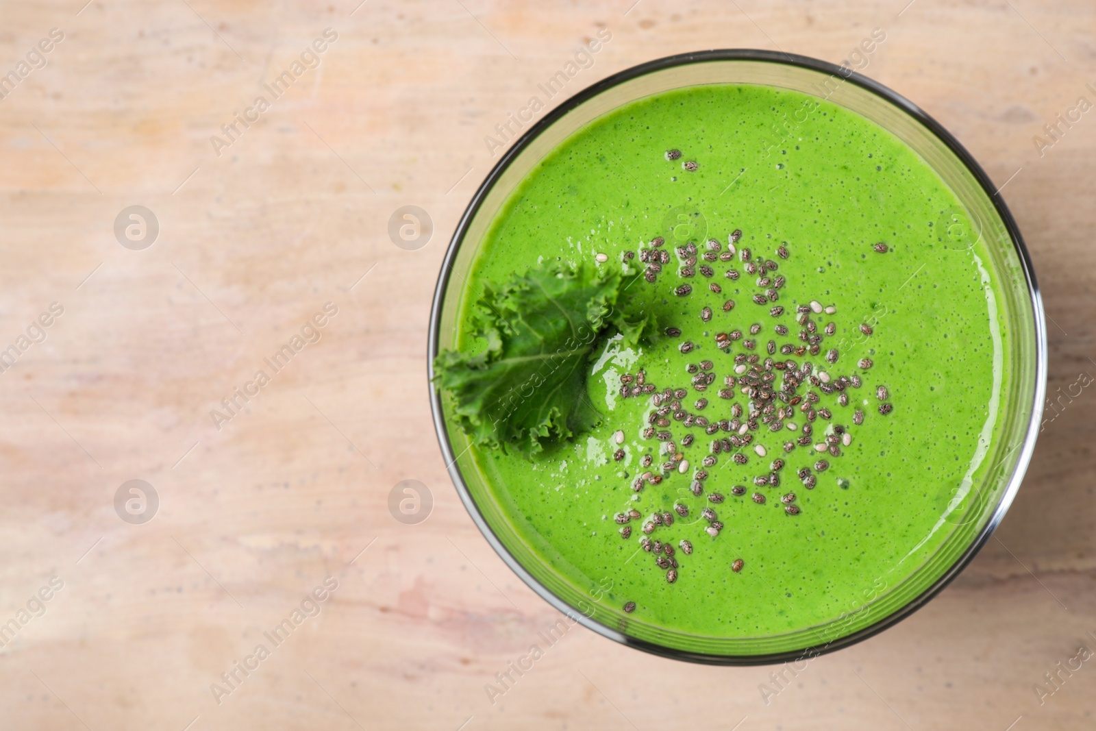 Photo of Tasty kale smoothie with chia seeds on wooden table, top view. Space for text