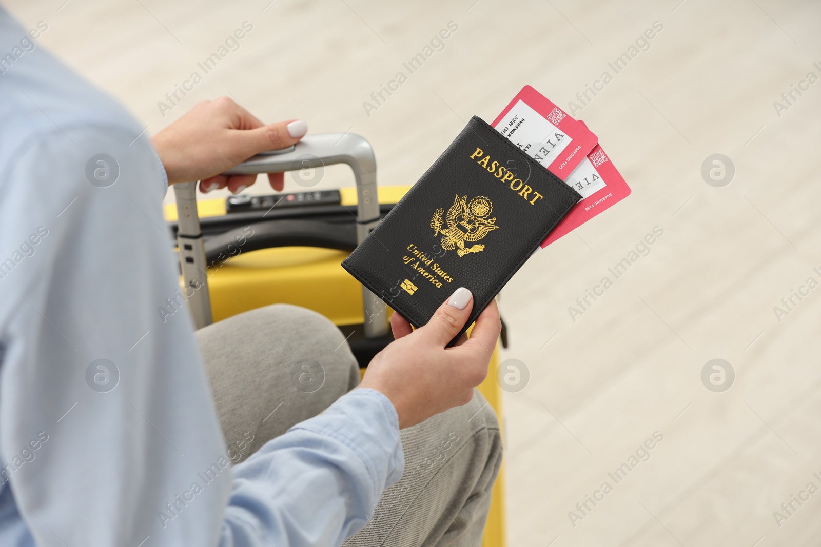 Photo of Woman with suitcase, passport and tickets on blurred background, closeup