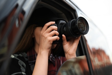 Photo of Private detective with camera spying from car