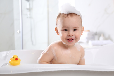 Cute little baby in bathtub at home