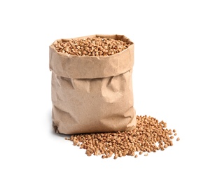 Paper bag with uncooked buckwheat on white background