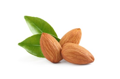 Photo of Organic almond nuts and green leaves on white background. Healthy snack