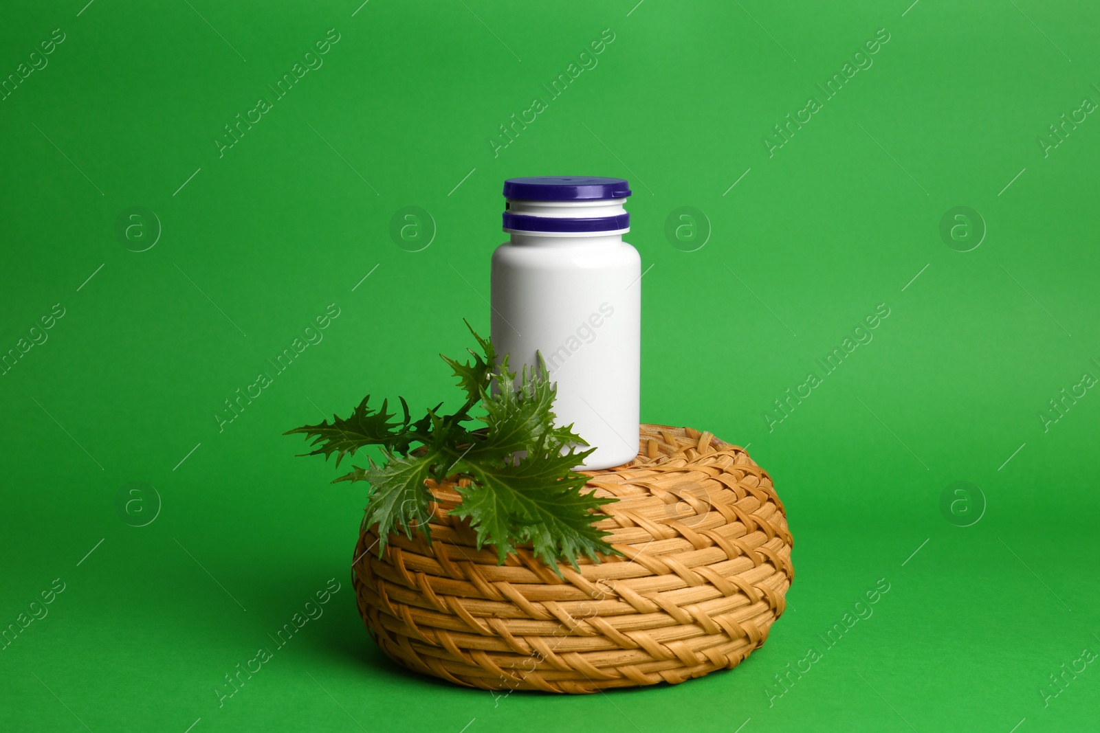 Photo of Stylish presentation of medicine bottle on green background