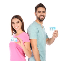 Happy young people with driving licenses on white background