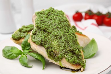 Photo of Delicious chicken breasts with pesto sauce and basil on table, closeup