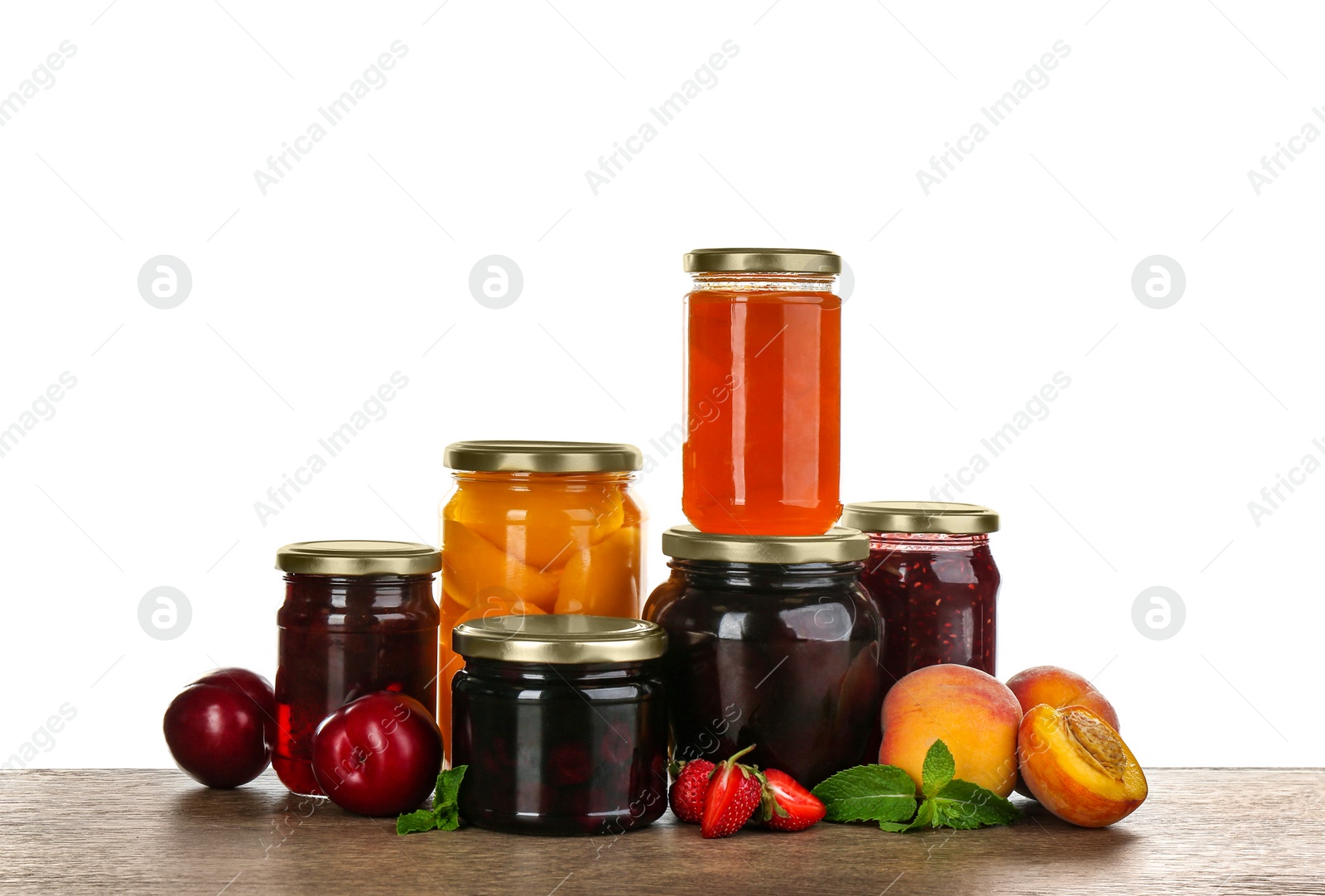 Photo of Jars of pickled fruits and jams on grey table