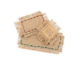 Photo of Pieces of burlap fabric with different stitches isolated on white, top view