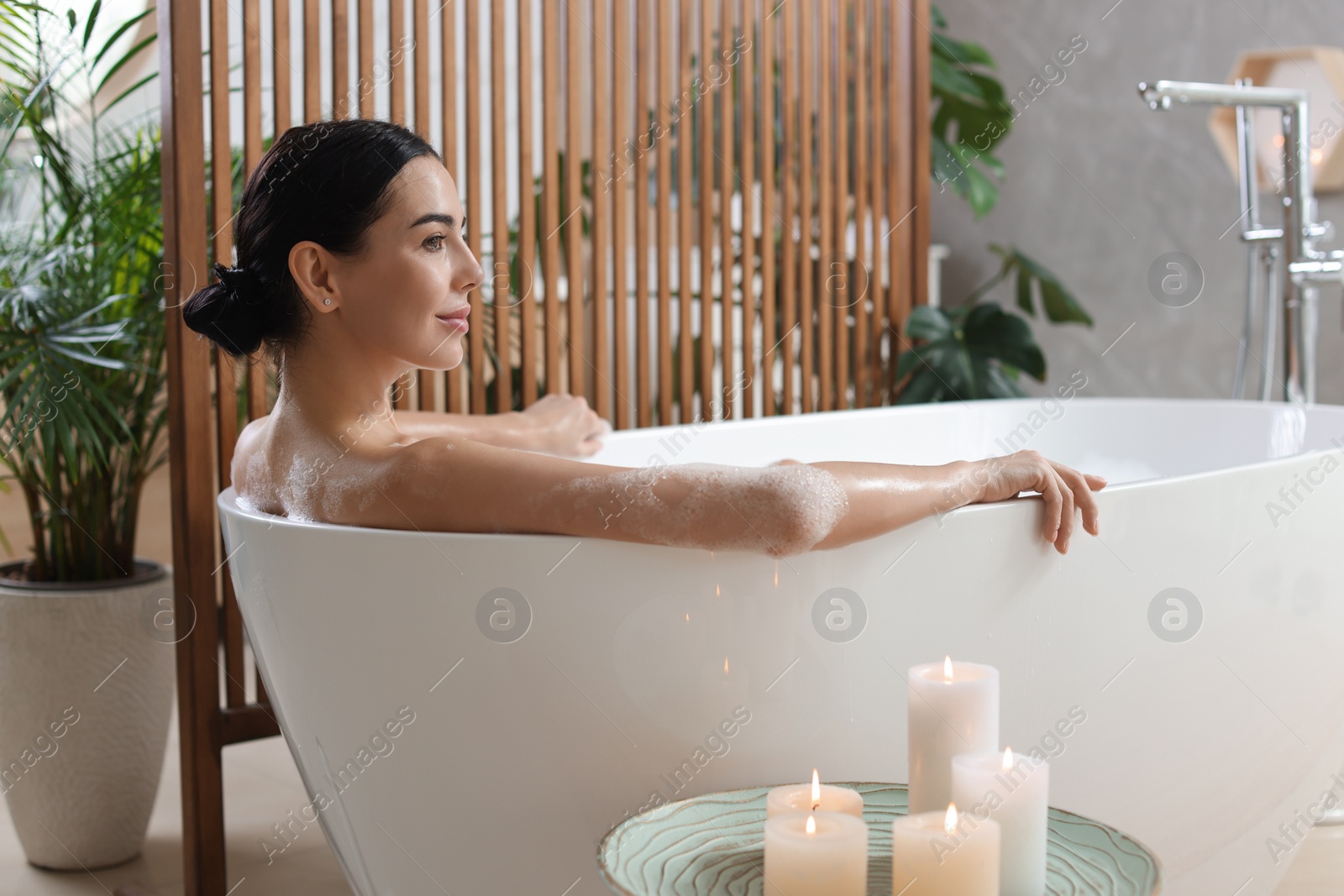 Photo of Beautiful young woman taking bubble bath at home