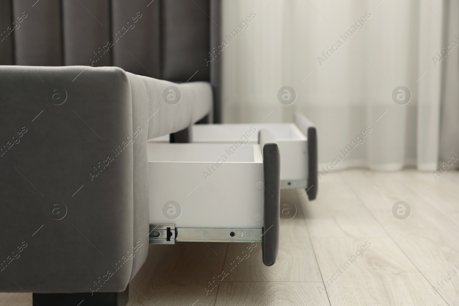 Photo of Storage drawers for bedding under modern bed in room. Space for text