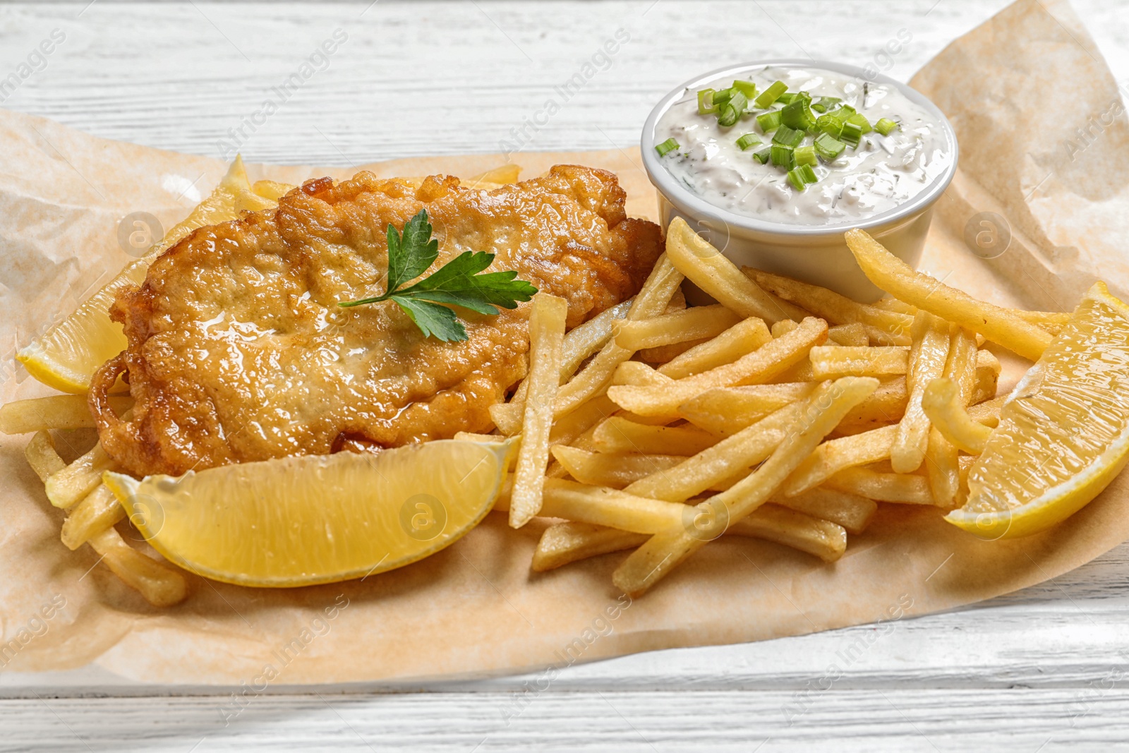 Photo of British traditional fish and potato chips on table