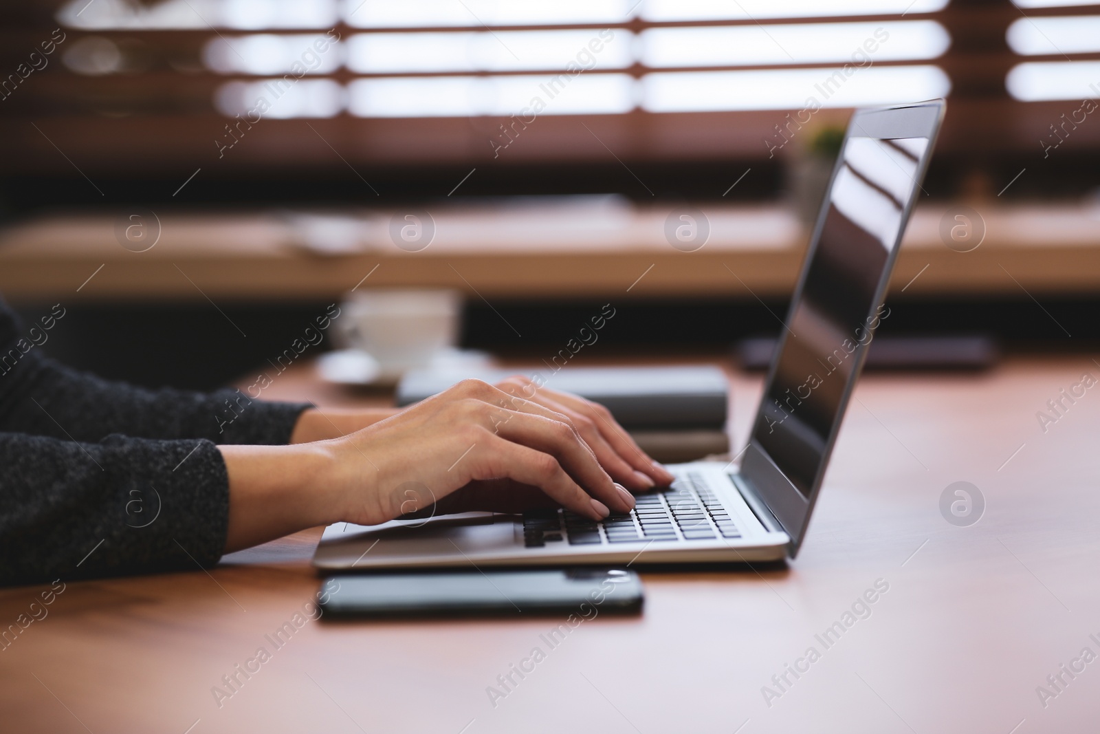 Photo of Woman working on modern laptop at table, closeup