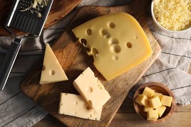 Photo of Grated, cut cheese and grater on wooden table, flat lay