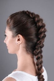 Photo of Woman with braided hair on grey background