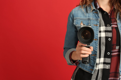 Woman with vintage video camera on red background, closeup. Space for text