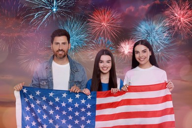 Image of 4th of July - Independence day of America. Happy family holding national flag of United States against sky with fireworks