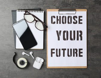 Flat lay composition with phrase CHOOSE YOUR FUTURE on grey stone background