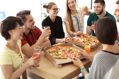 Photo of Young people having fun party with delicious pizza indoors