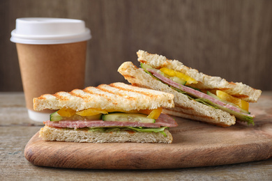 Photo of Tasty sandwich with ham on wooden table