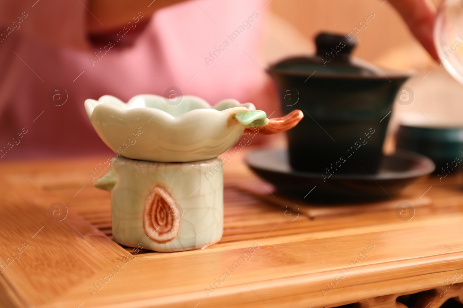 Photo of Beautiful ceramic filter for traditional tea ceremony on wooden stand