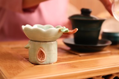 Beautiful ceramic filter for traditional tea ceremony on wooden stand