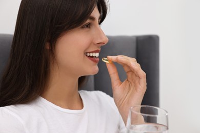 Photo of Beautiful woman taking vitamin pill at home