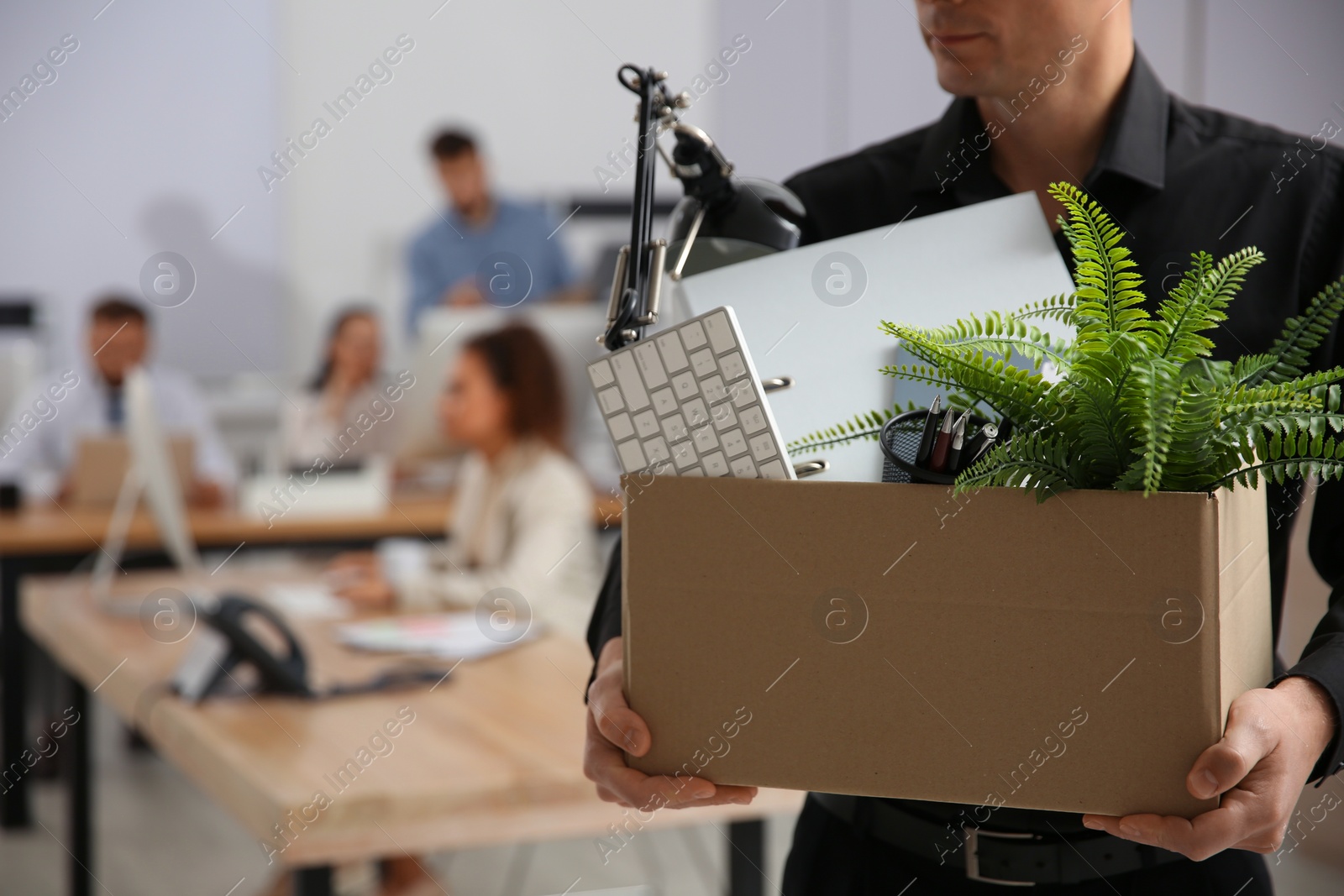 Photo of Dismissed man carrying box with stuff in office, closeup