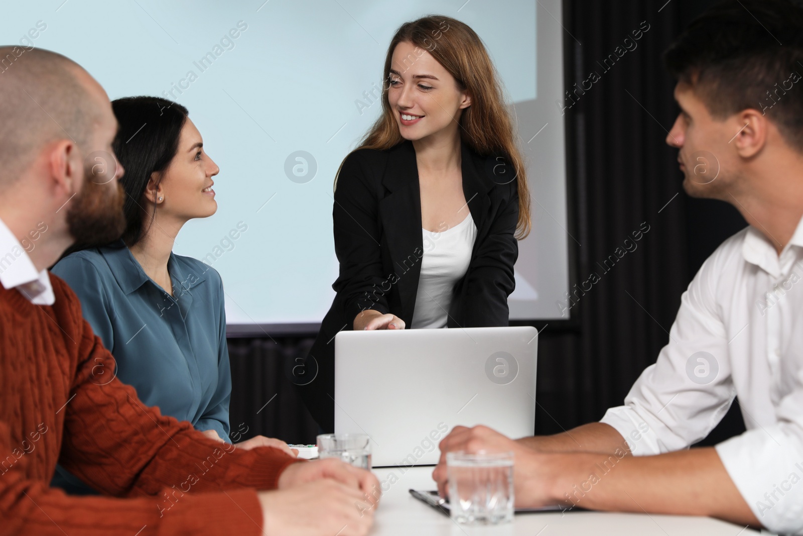 Photo of Business people having meeting in conference room with video projection screen