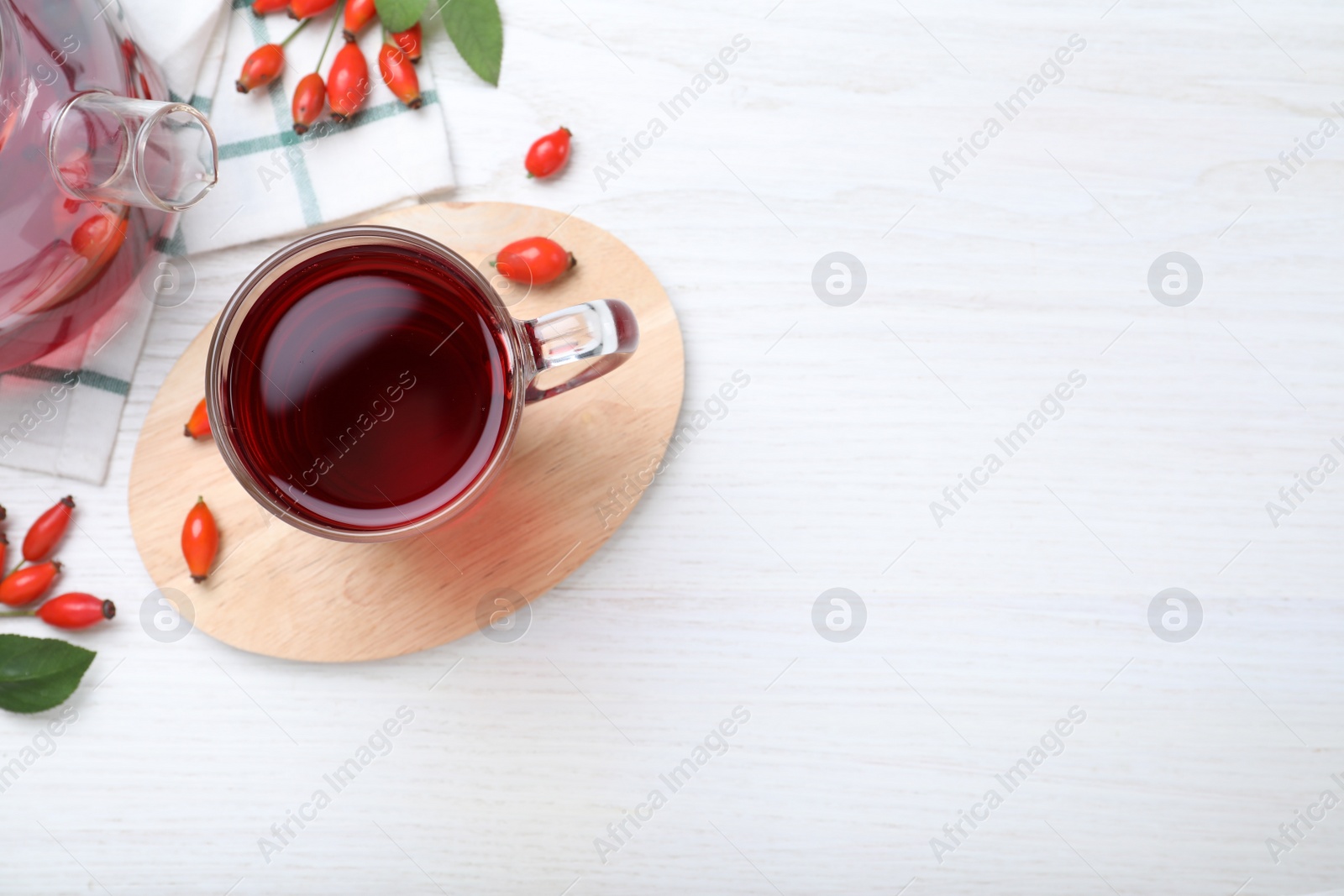 Photo of Flat lay composition with aromatic rose hip tea on white wooden table. Space for text