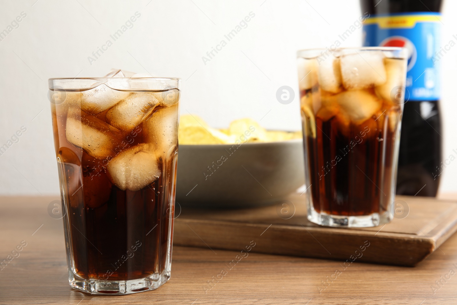 Photo of MYKOLAIV, UKRAINE - FEBRUARY 15, 2021: Glasses of Pepsi on wooden table