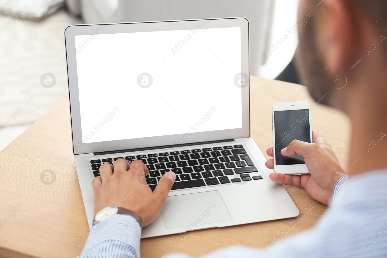 Image of Young man using modern computer at table in office, closeup. Space for design