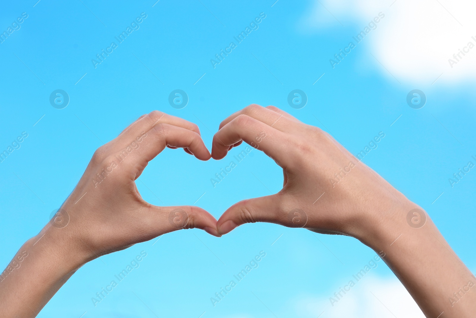 Photo of Woman making heart with her hands on color background, closeup