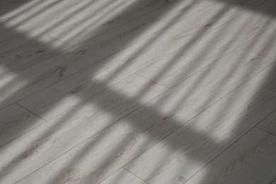 Shadow from window and curtains on white laminated floor