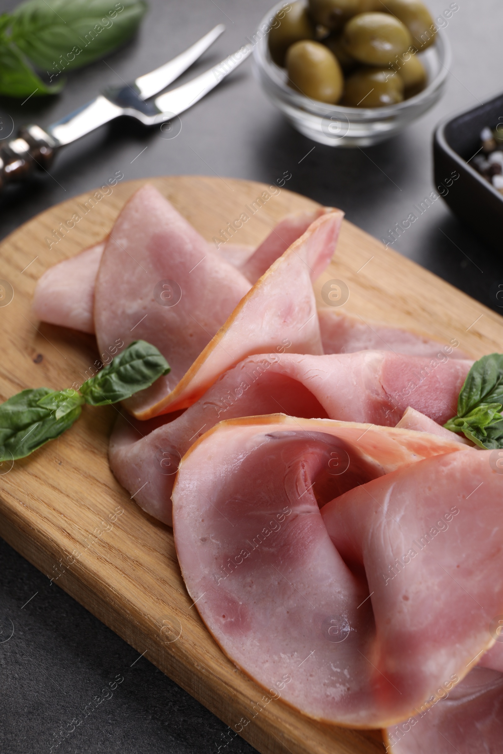 Photo of Tasty ham with basil on grey table, closeup