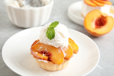 Photo of Delicious peach dessert with ice cream on table, closeup