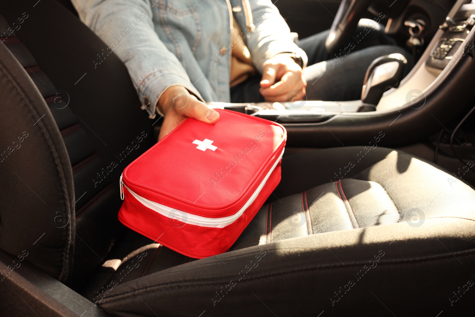 Photo of Man with first aid kit inside car, closeup