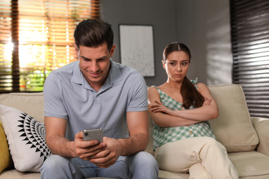 Man preferring smartphone over spending time with his girlfriend at home. Jealousy in relationship
