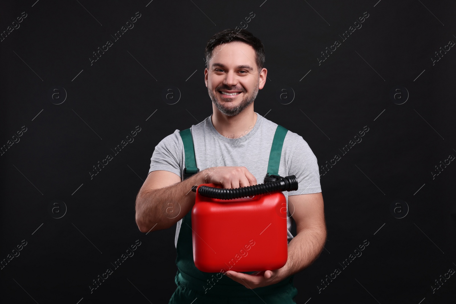Photo of Man holding red canister on black background