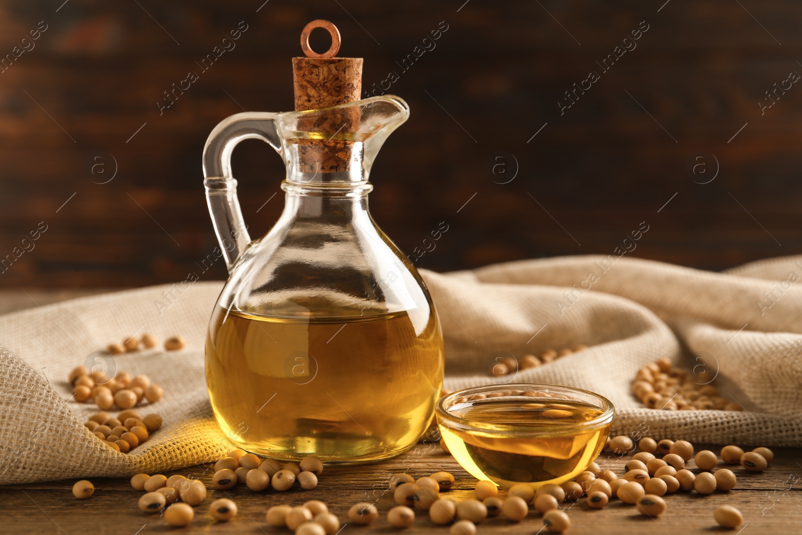 Photo of Composition with soybean oil on wooden table