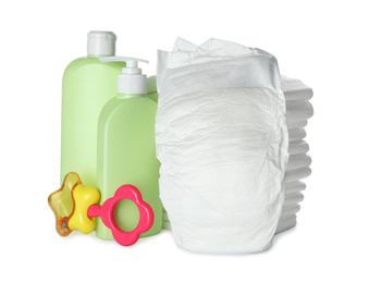 Photo of Disposable diapers, teether and toiletries on white background