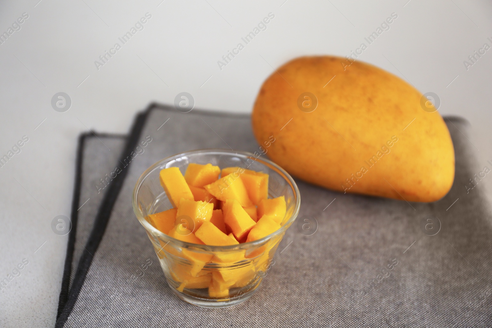 Photo of Delicious cut and whole mangoes on light table