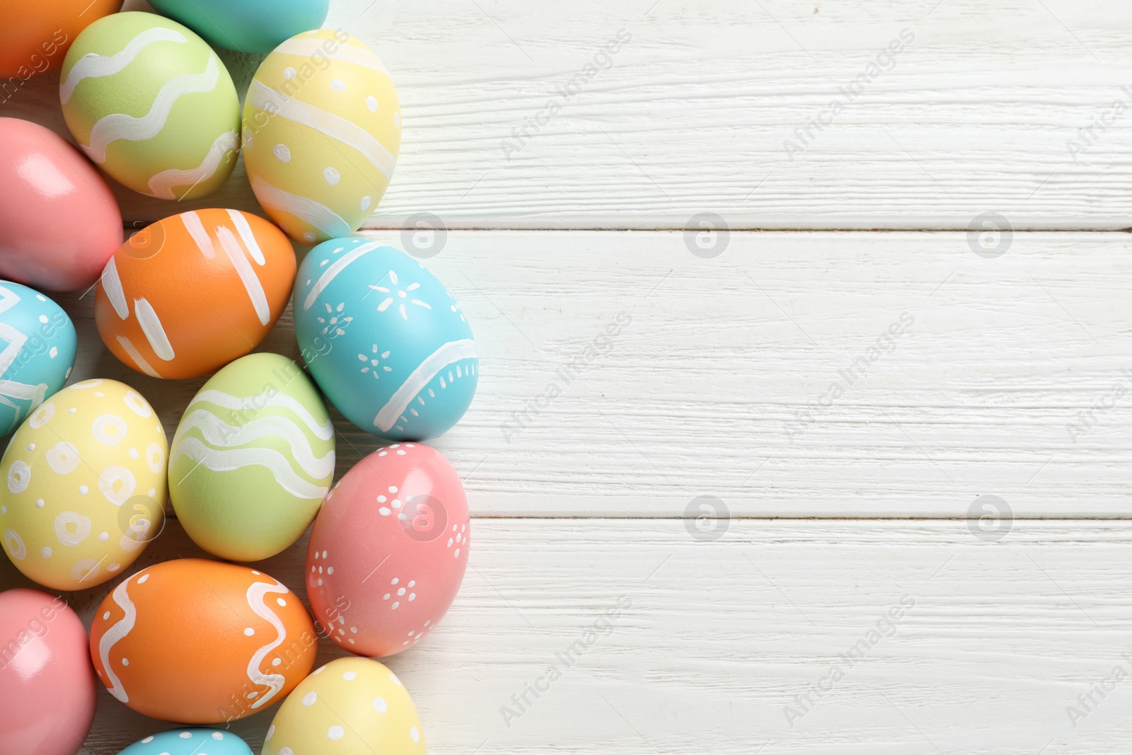 Photo of Many colorful painted Easter eggs on wooden background, top view. Space for text