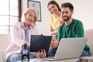 Female notary working with young couple in office