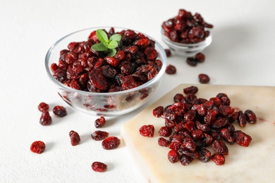 Photo of Tasty dried cranberries and leaves on white table