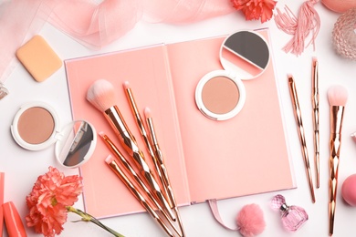 Flat lay composition with coral accessories, notebook and flowers on white background